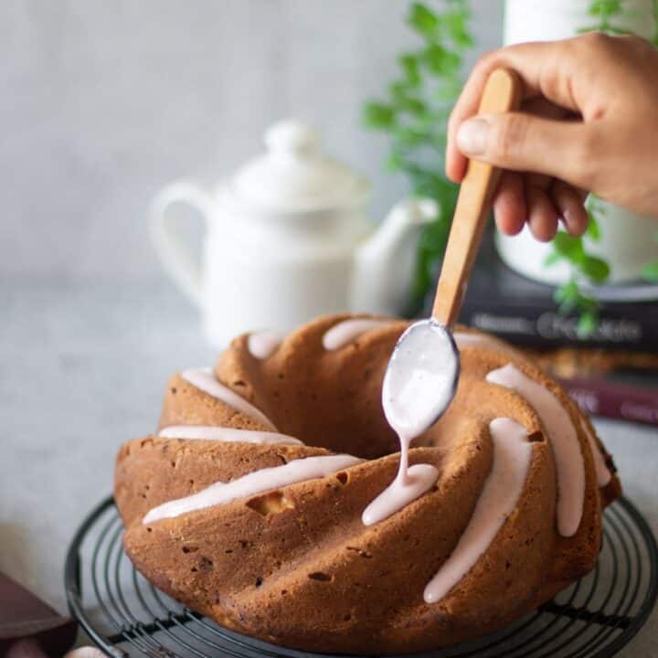 pouring strawberry glaze over strawberry pound cake