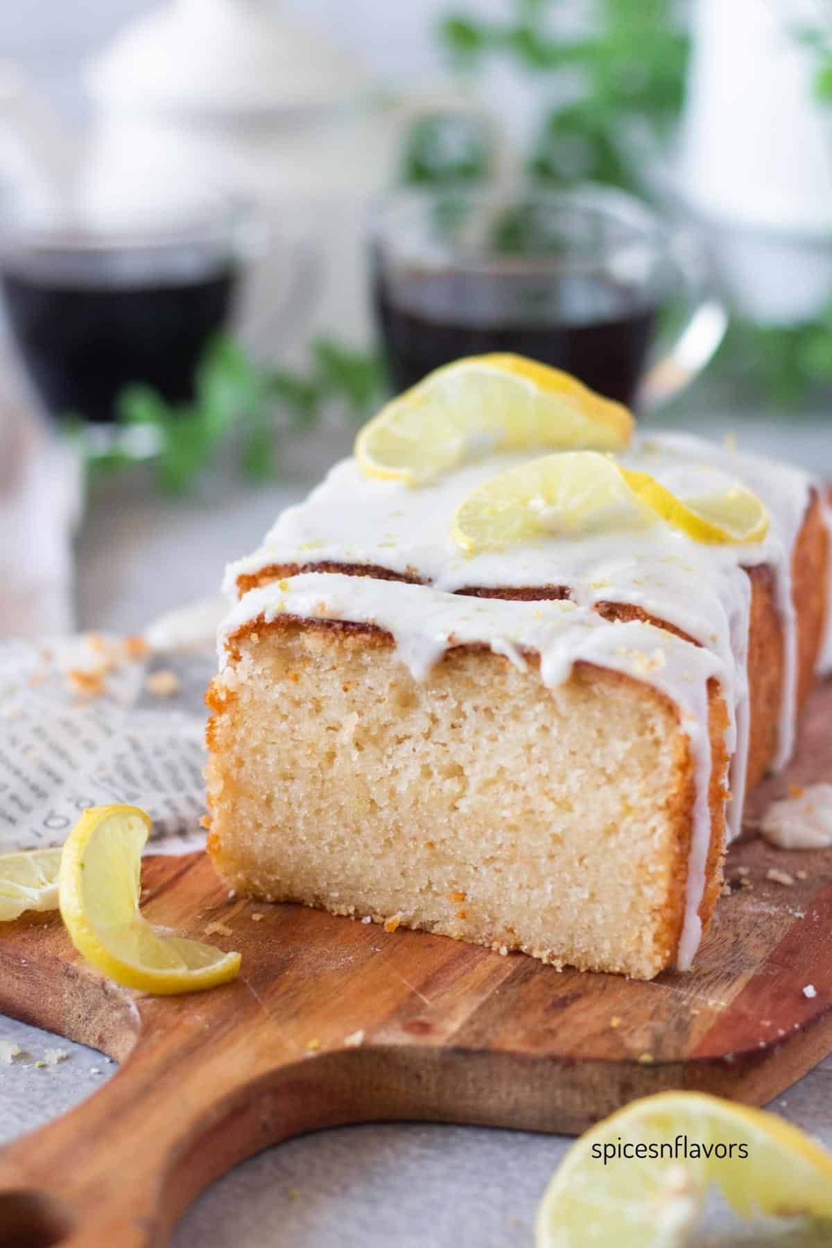 sliced eggless lemon loaf cake placed on wooden board