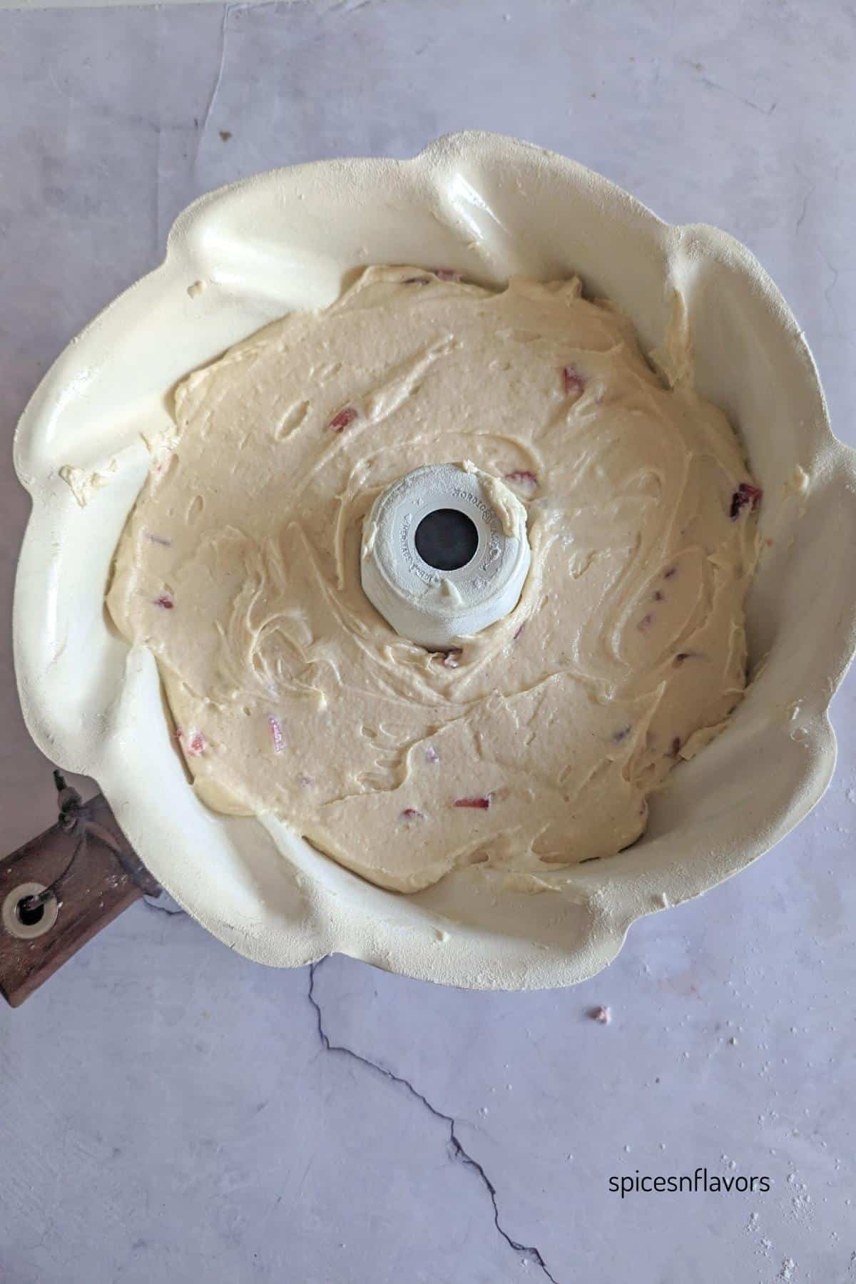 adding cake batter to the bundt pan