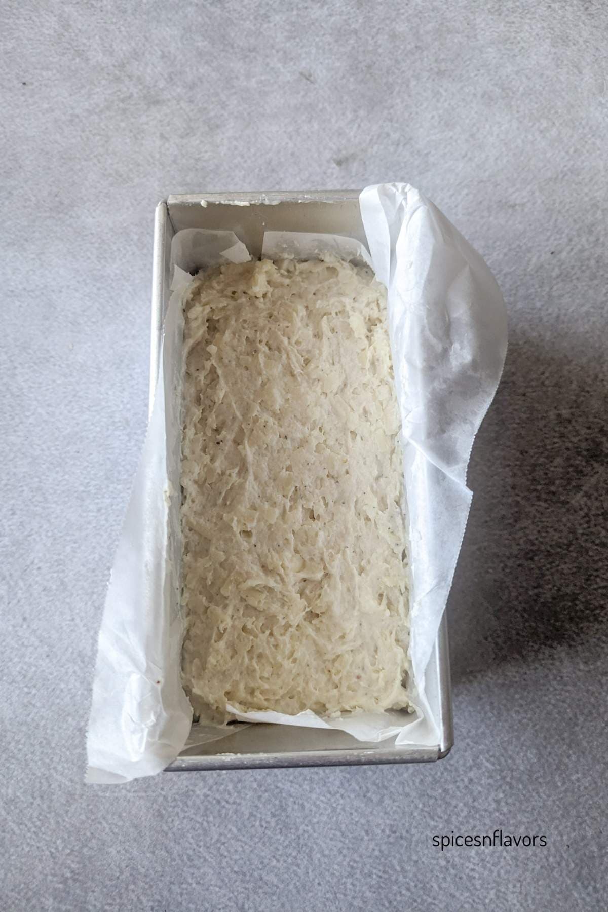 transferring cheddar cheese bread batter to a pan
