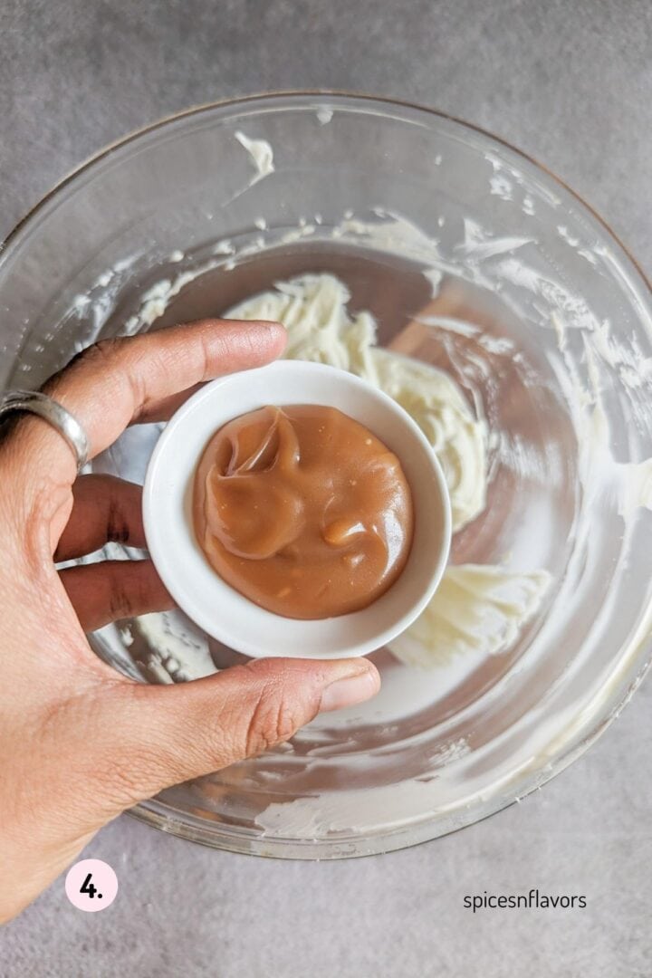 adding caramel sauce to the buttercream