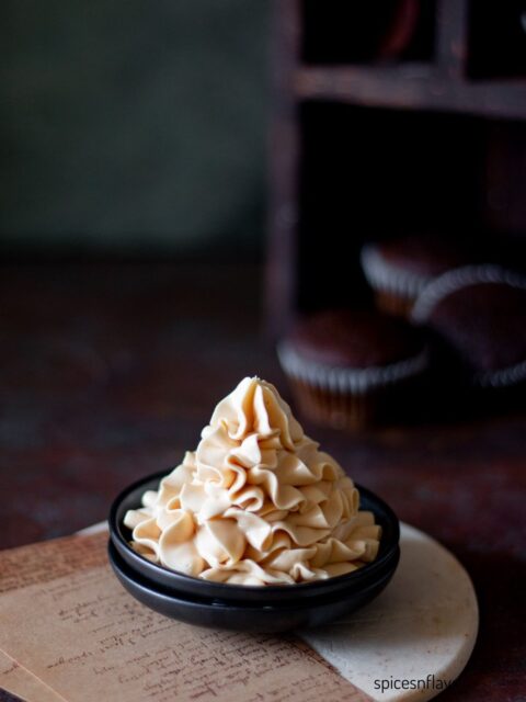 caramel frosting piped on a small black plate