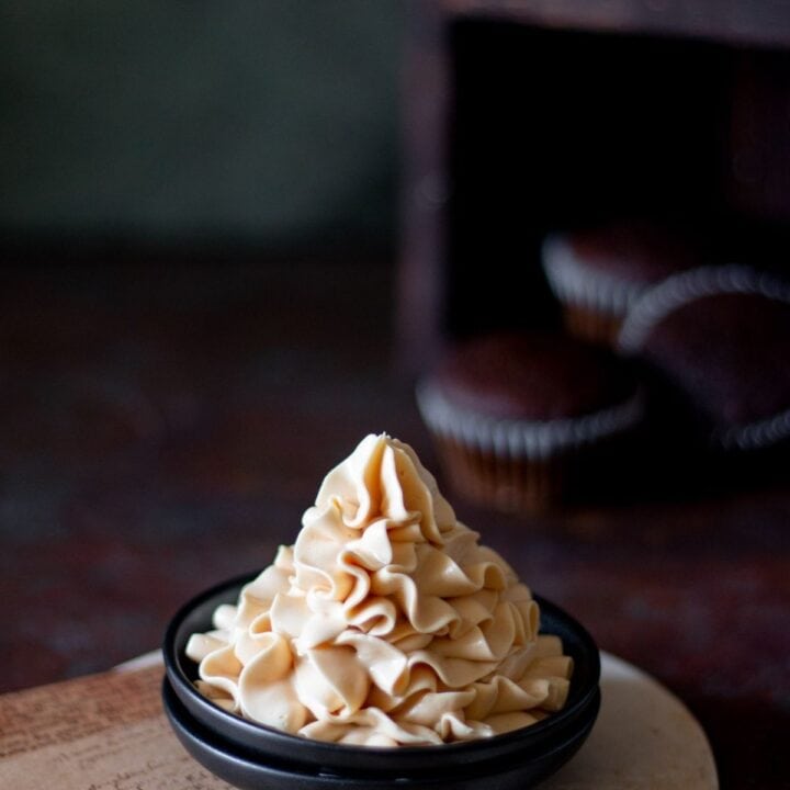 caramel frosting piped on a small black plate