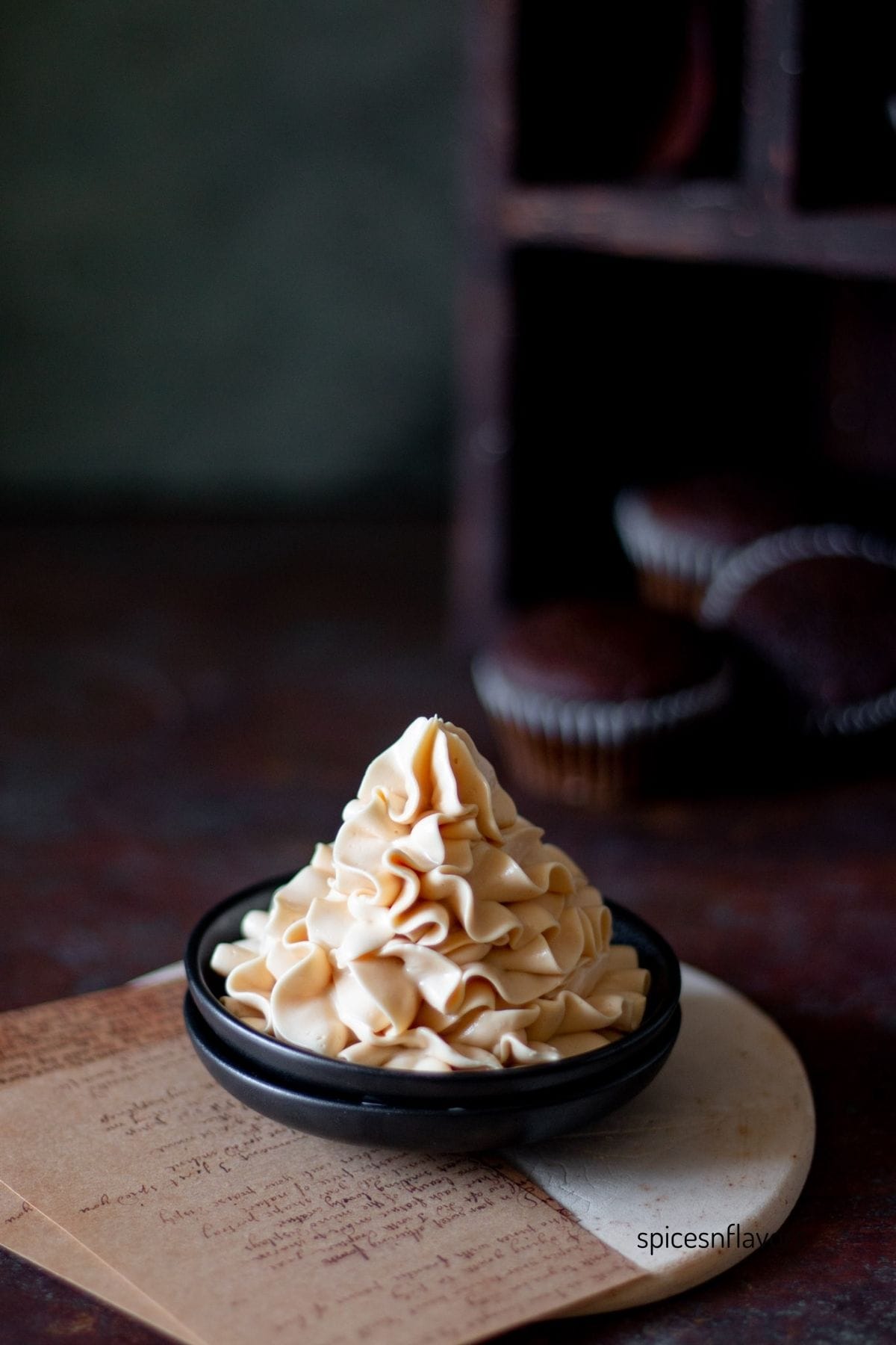 caramel frosting piped on a small black plate