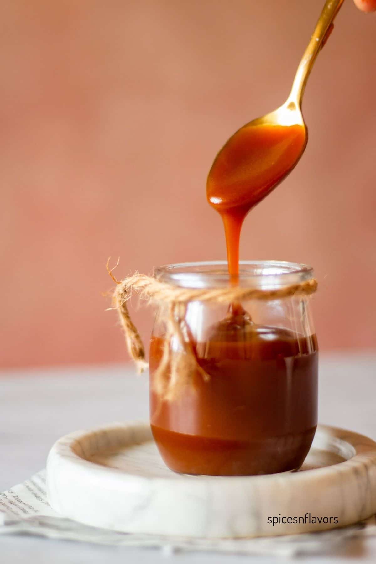 caramel sauce flowing through a large spoon showing the silkiness