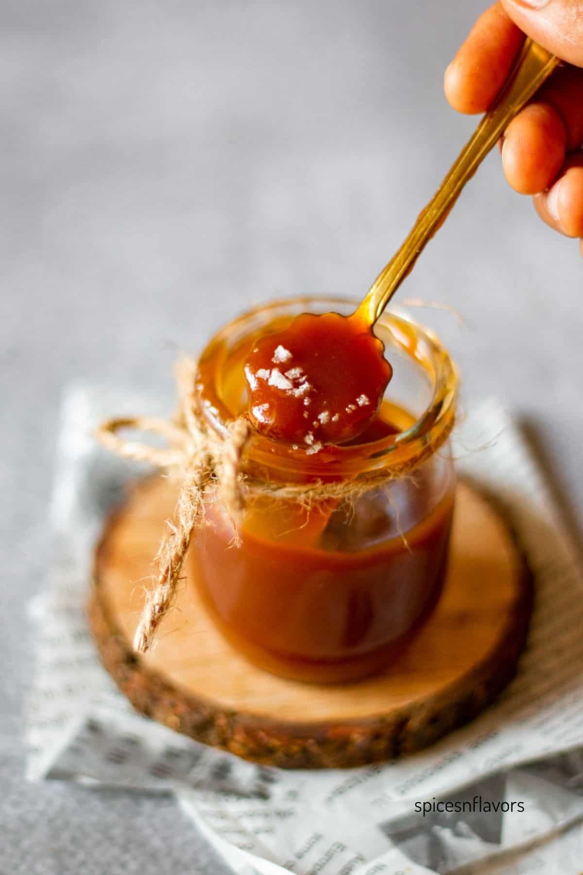 salt sprinkled on top of a spoonful of caramel sauce