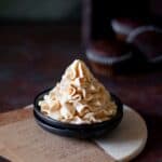 cropped up image of caramel frosting on a black plate to fit the recipe card