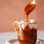 cropped image of caramel sauce dripping from spoon for recipe card
