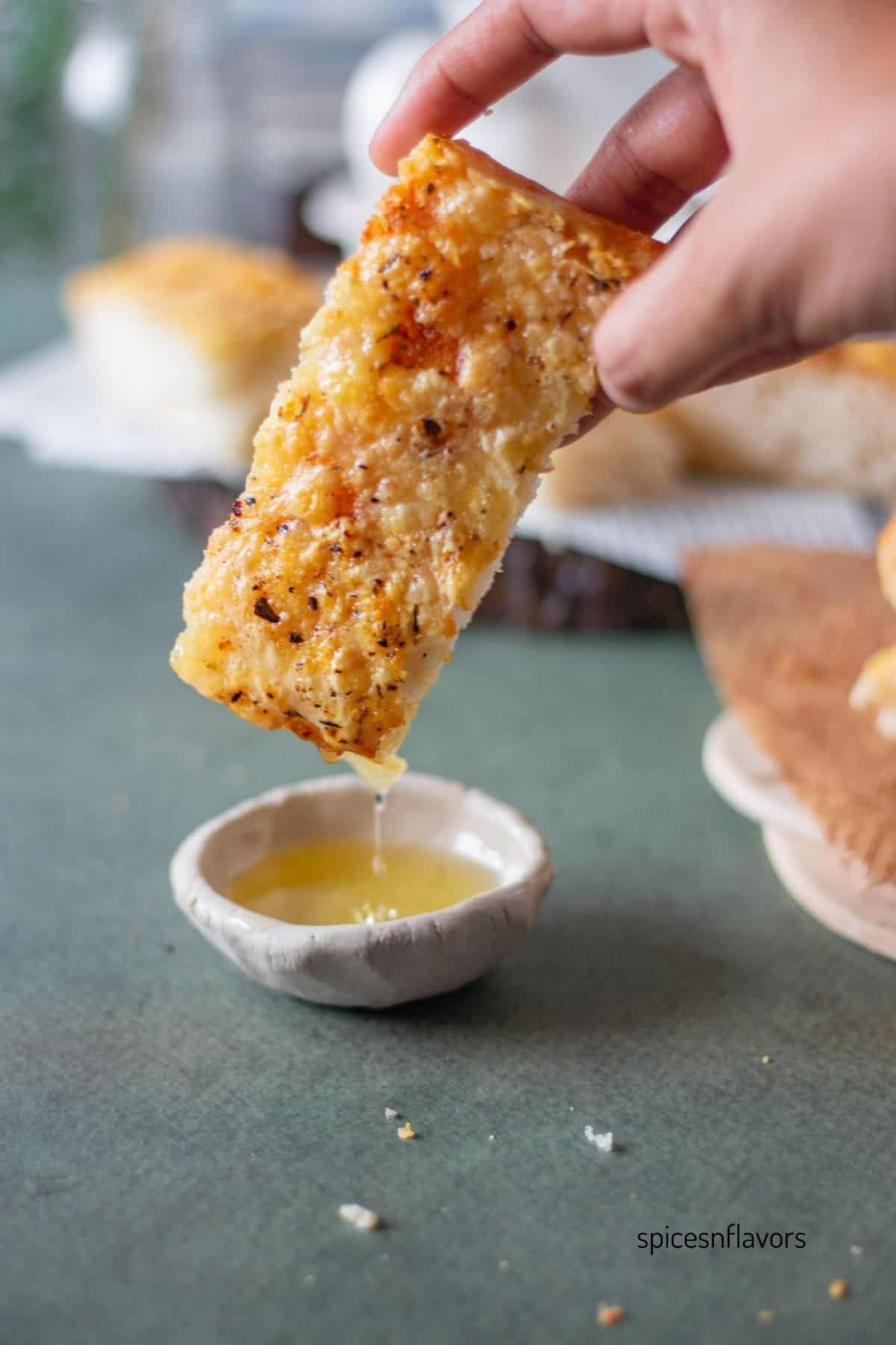 oil dripping from the slice of italian cheese bread