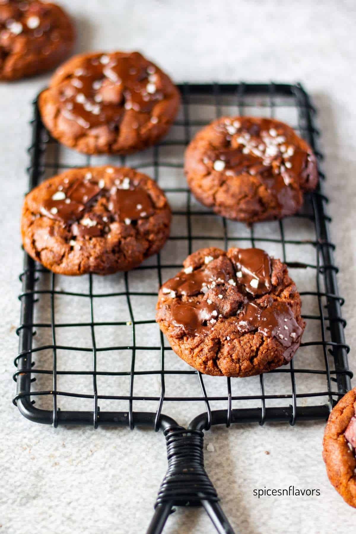 five espresso cookies with dark chocolate chunks placed on a wire rack