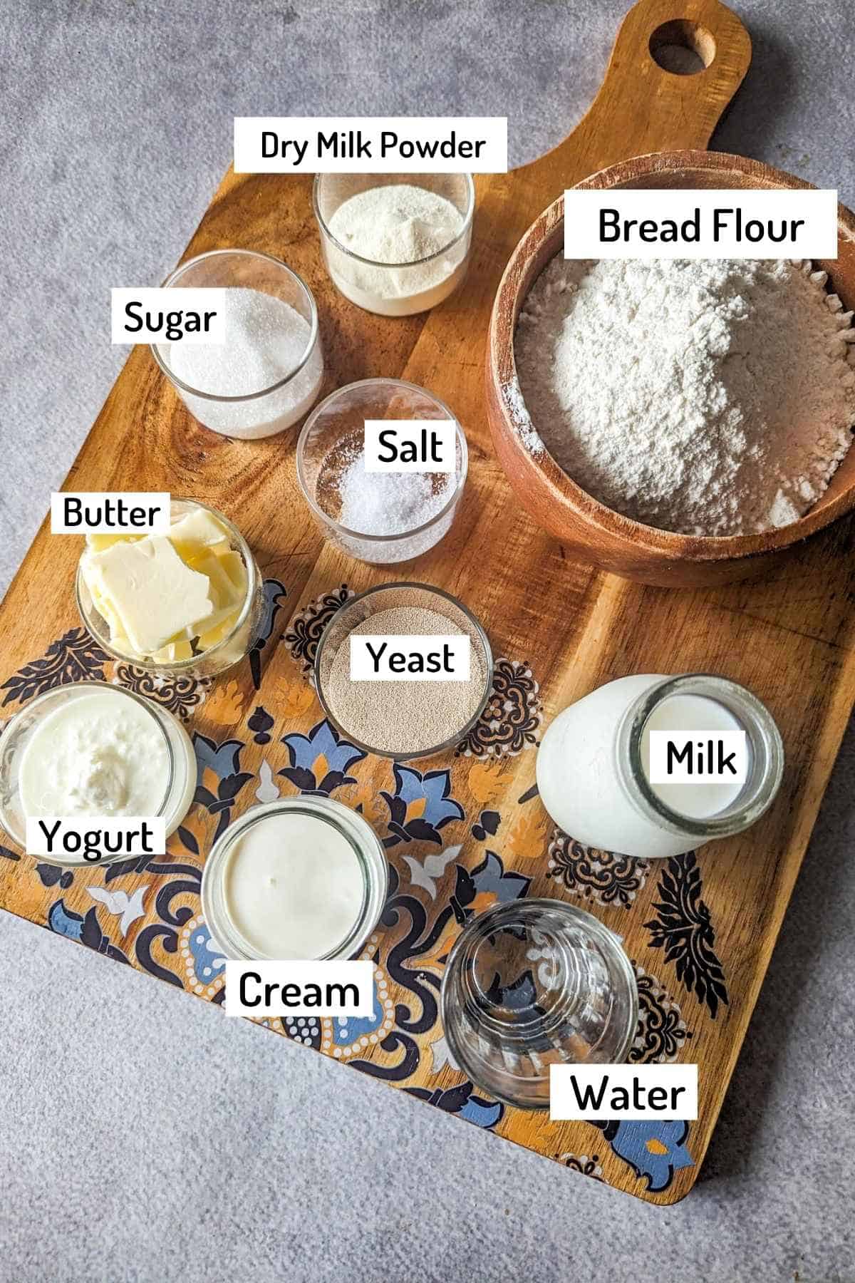 ingredients needed to make japanese milk bread machine recipe placed on a large wooden board