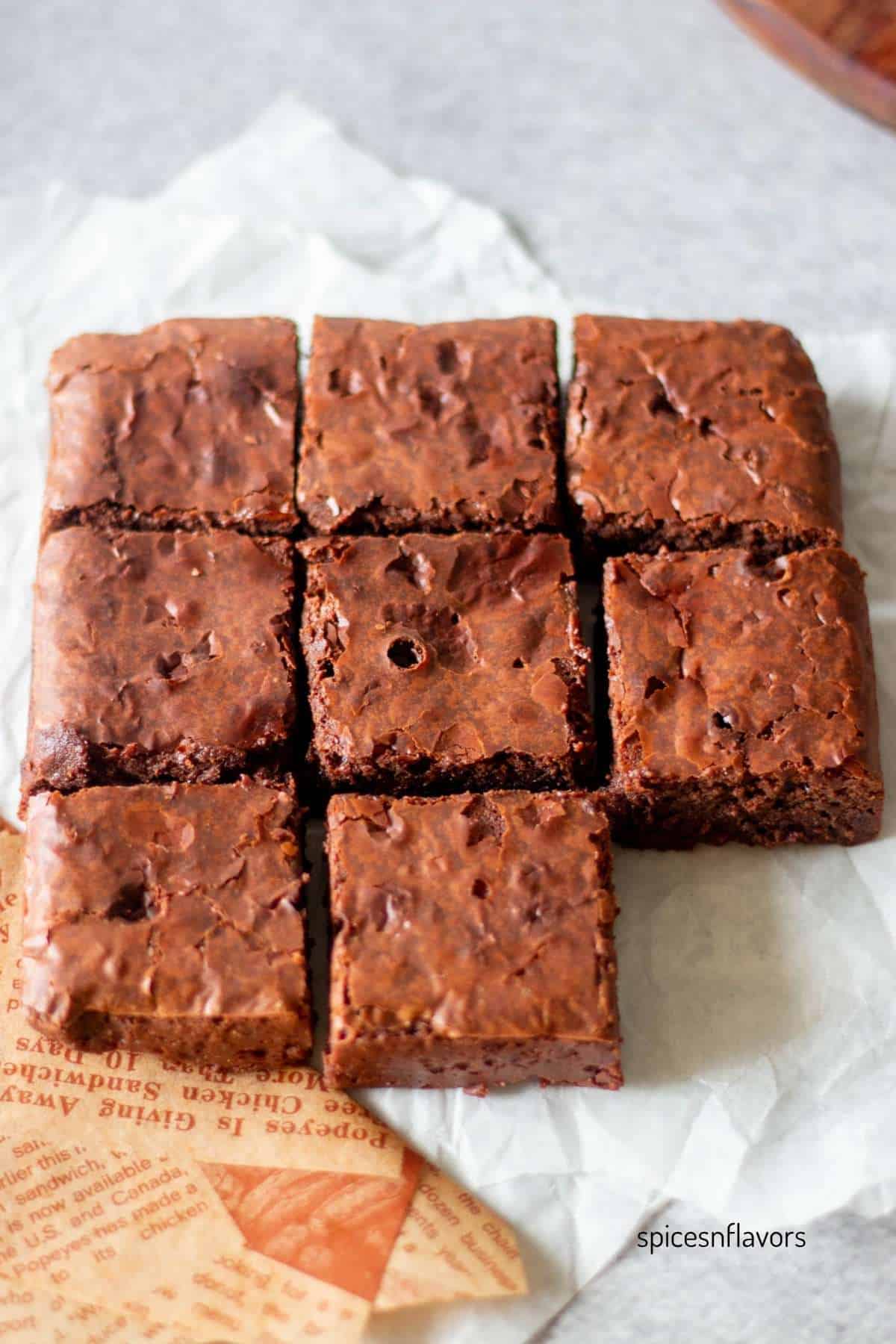 baked brownies sliced and placed on a white parchment paper