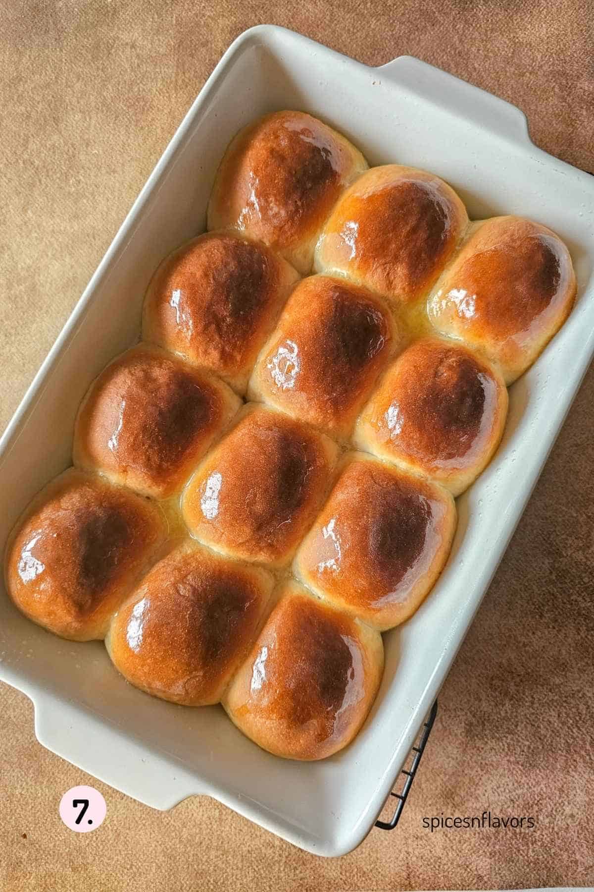 applying butter on baked dinner rolls