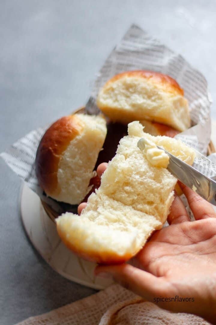 applying butter on dinner rolls
