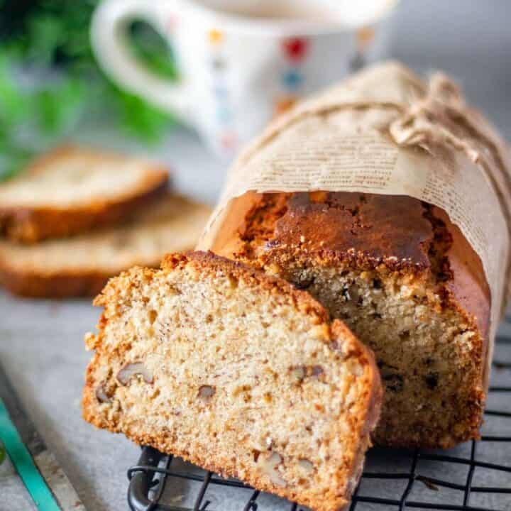 sliced banana bread placed on a wire rack with knife on the side