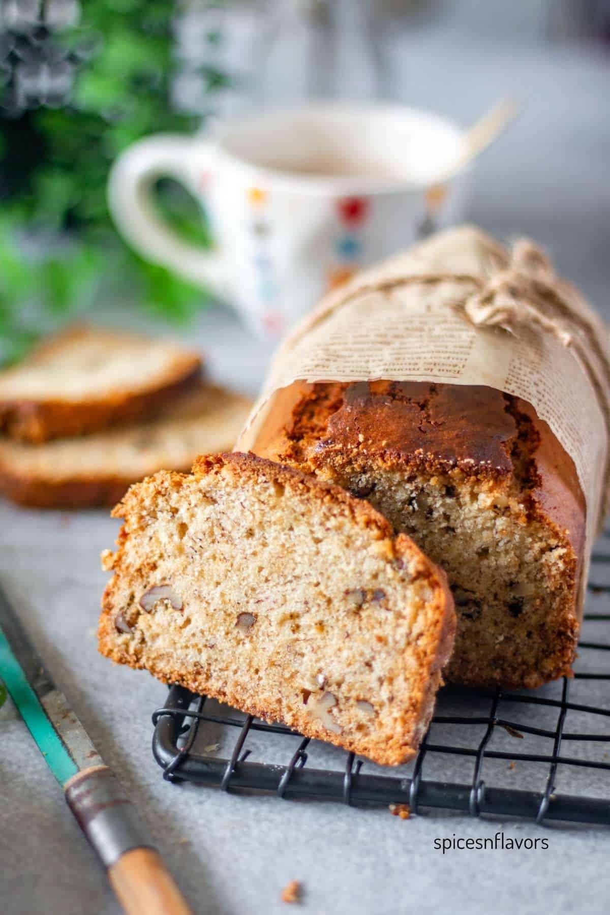 sliced banana bread placed on a wire rack with knife on the side