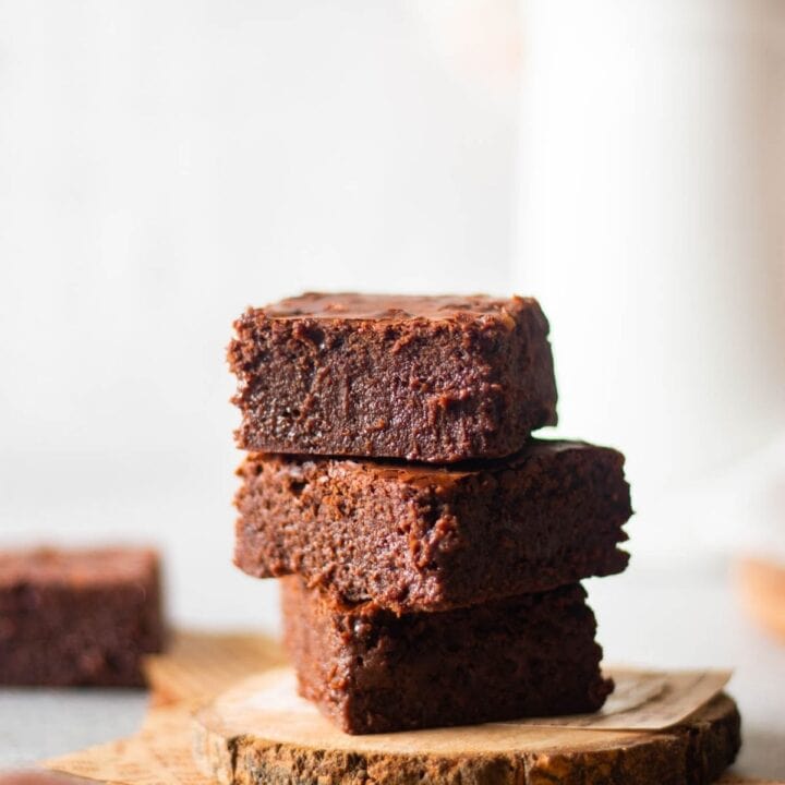 three pieces of stacked brownies placed on a wooden coaster