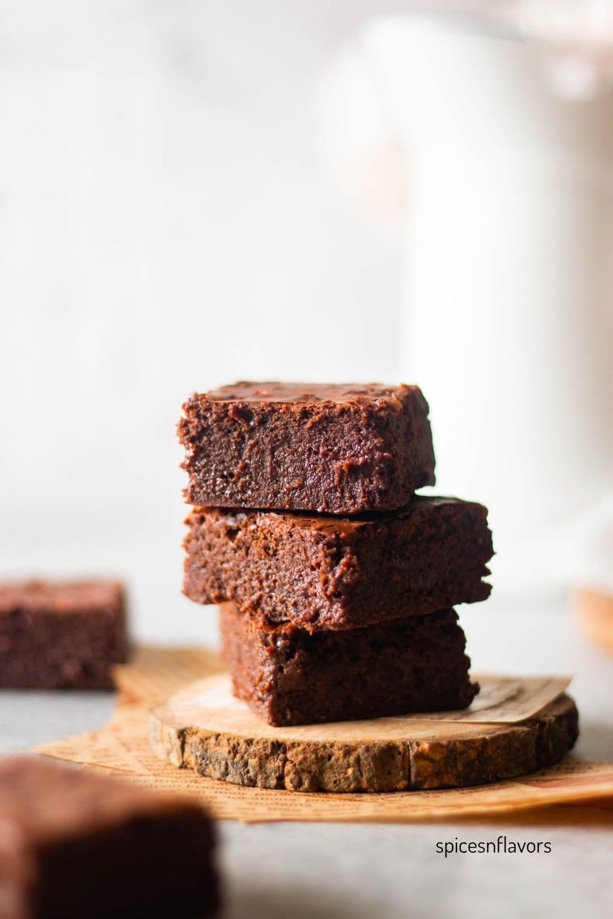 three pieces of stacked brownies placed on a wooden coaster