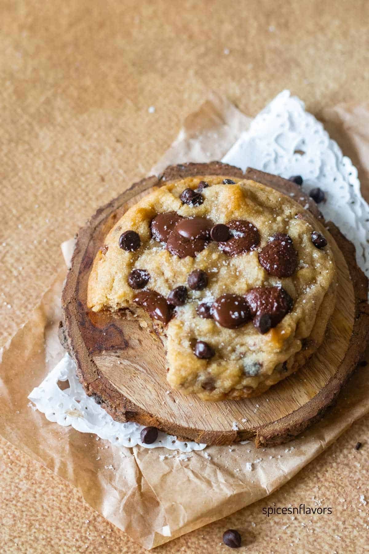 biting on one side of the chocolate chip cookie and placed on the coaster