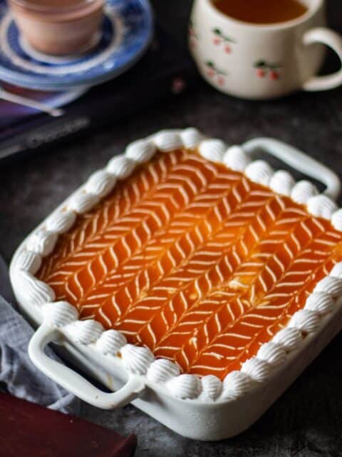 caramel tres leches cake with coffee in the background