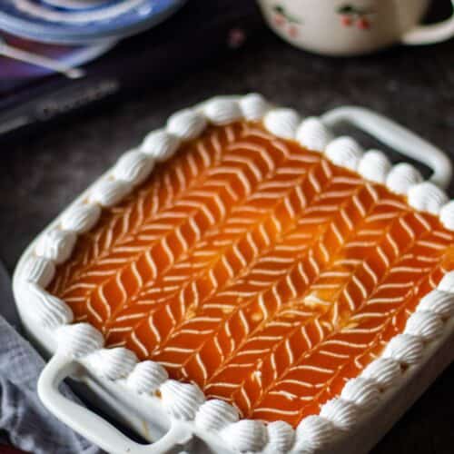 caramel tres leches cake with coffee in the background