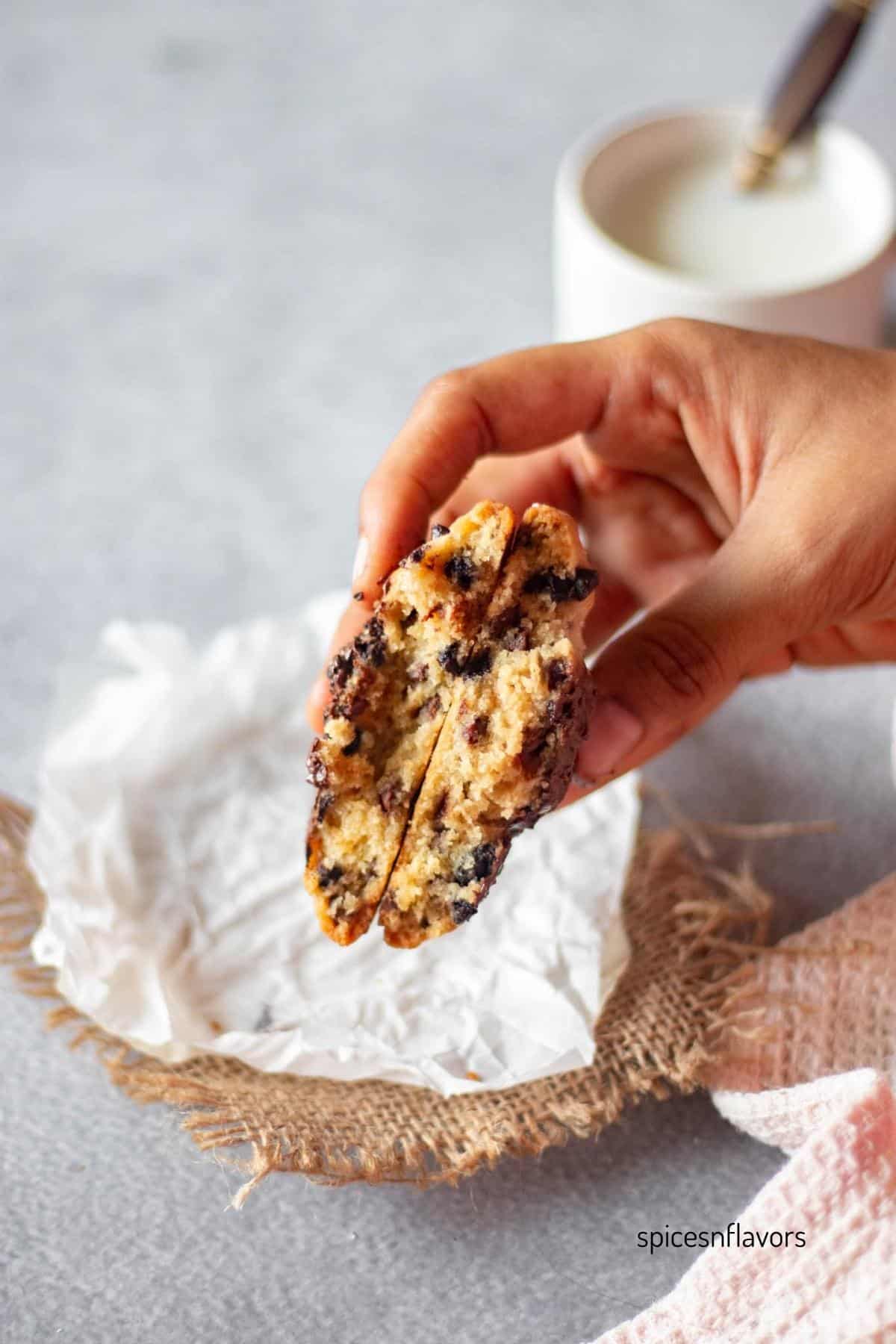 holding sliced chocolate chip cookie to show the texture within