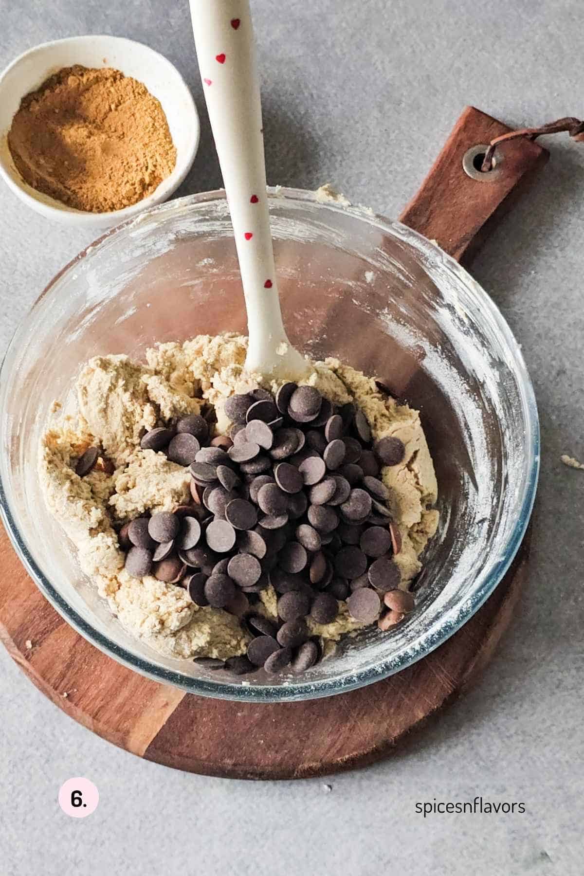 adding chocolate chips to the dough