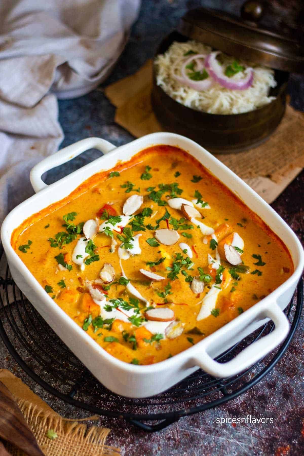 oven baked curry garnished with fresh cream, sliced almonds, chopped coriander