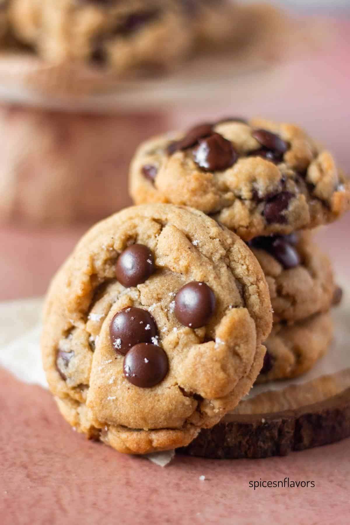 one chai chocolate chip cookie placed vertically in front of stacked cookies