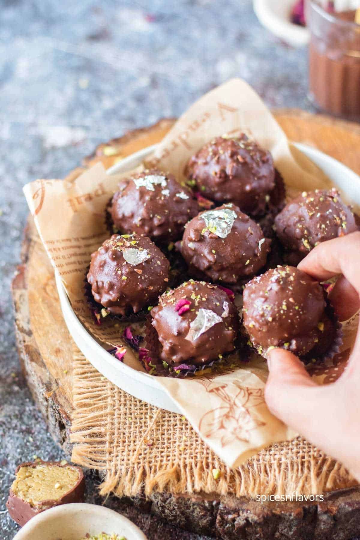 picking up a soan papdi truffle from the plate