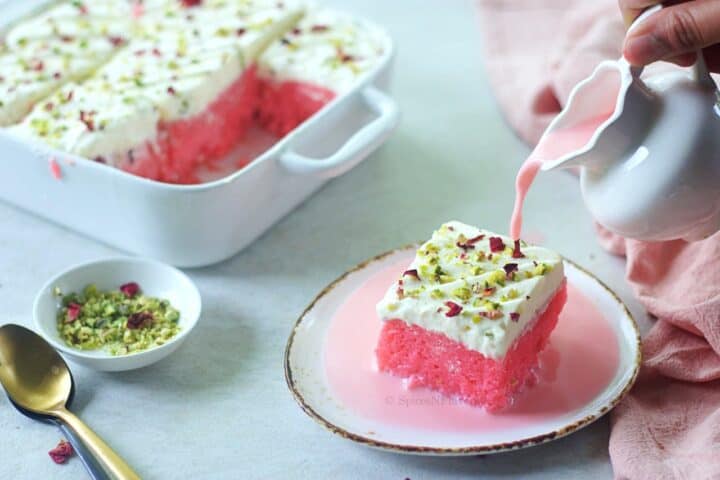 slice of rose milk cake placed on a plate