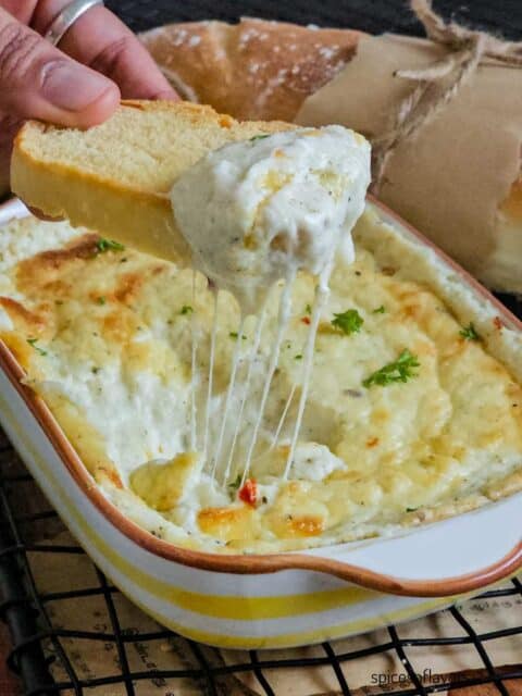 dipping bread into garlic cheese dip and pulling it up with cheese strings attached to it