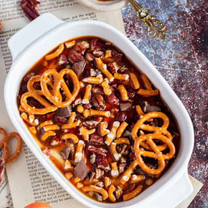 caramel dip served in an oval white bowl with apples on the side