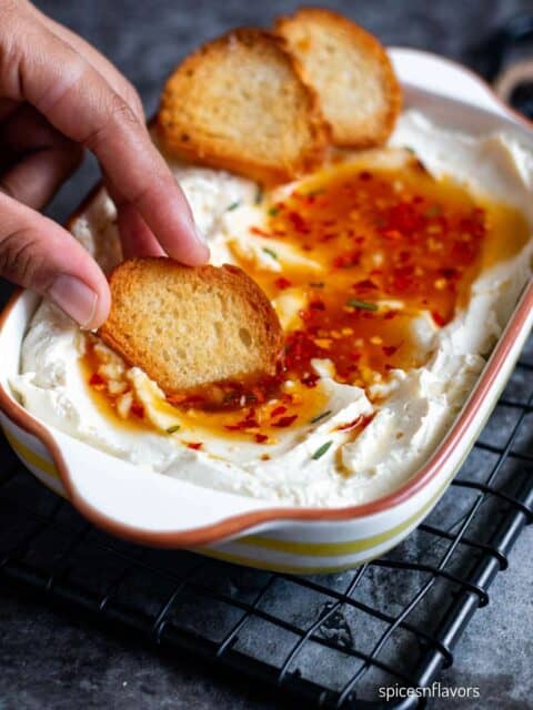 dipping bread in whipped feta dip with spicy honey