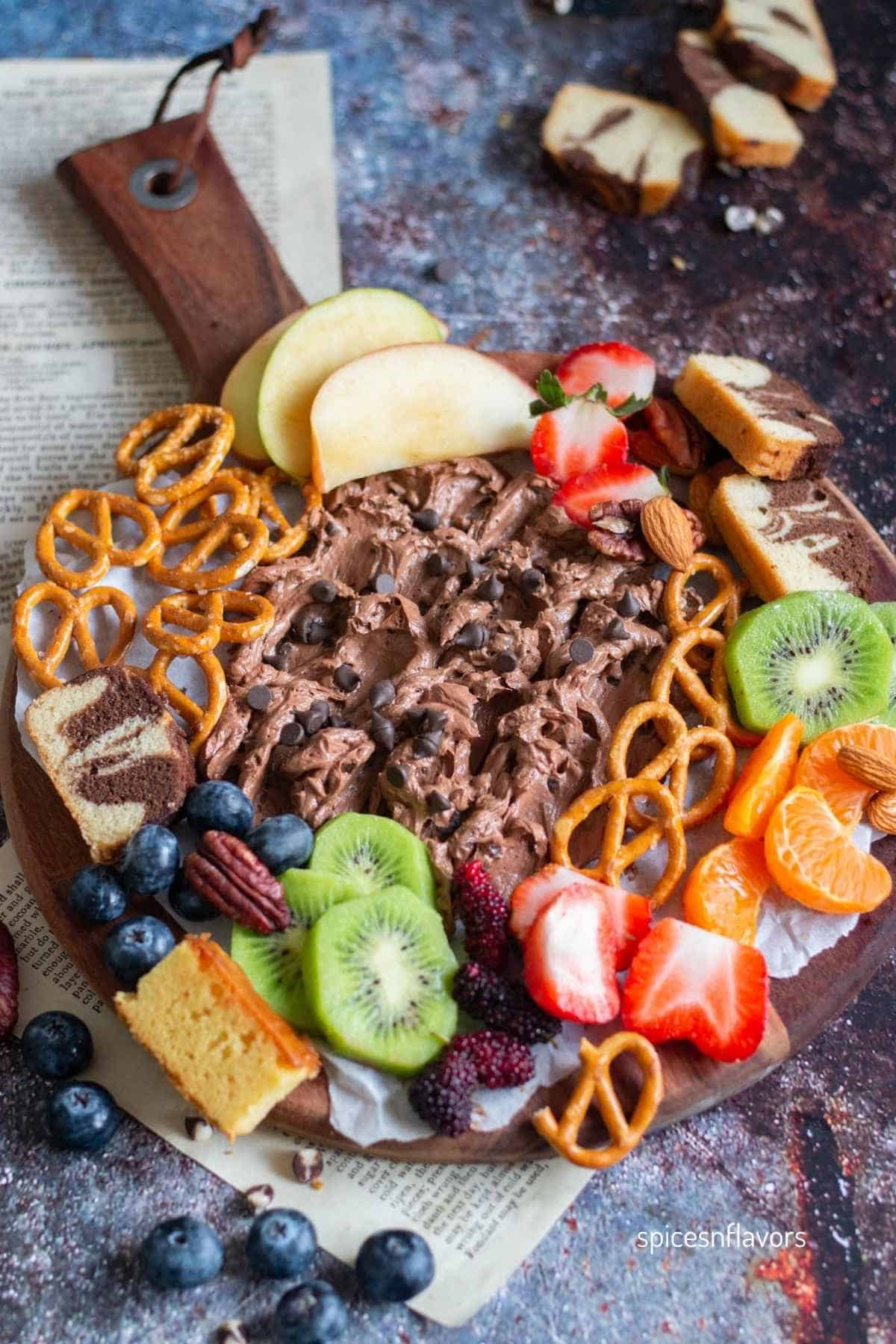 brownie batter dip spread on a wooden board with dippers on side