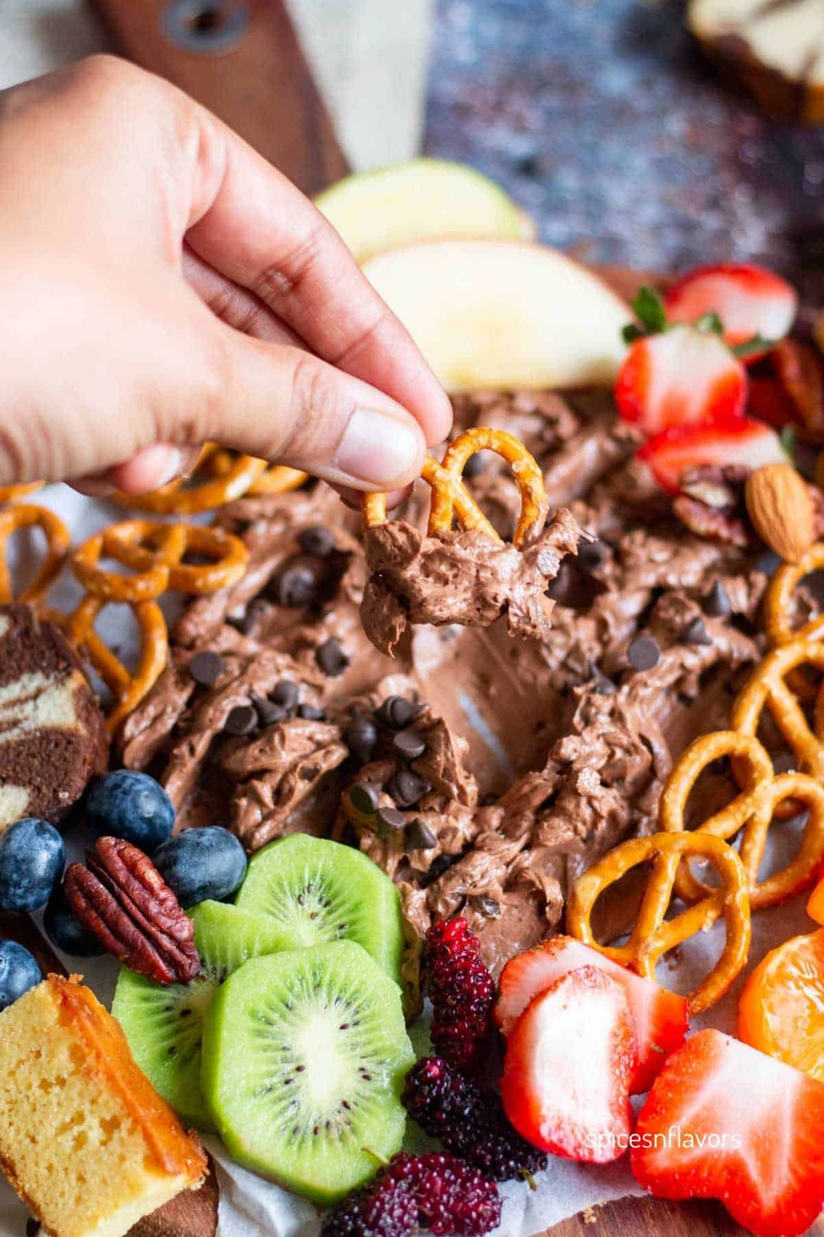 picking up the dip with pretzel