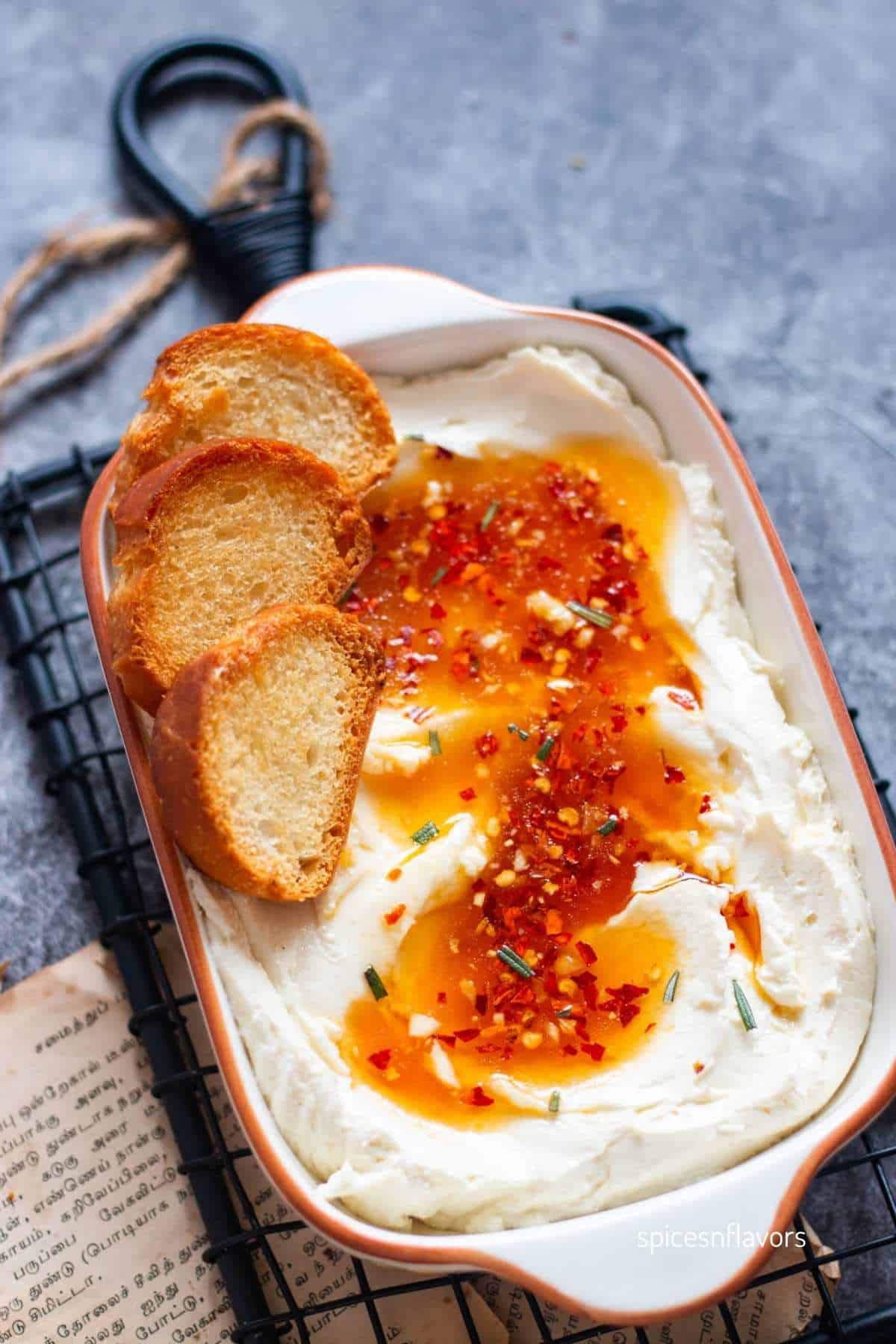 whipped feta dip placed in a bowl with bread on the side