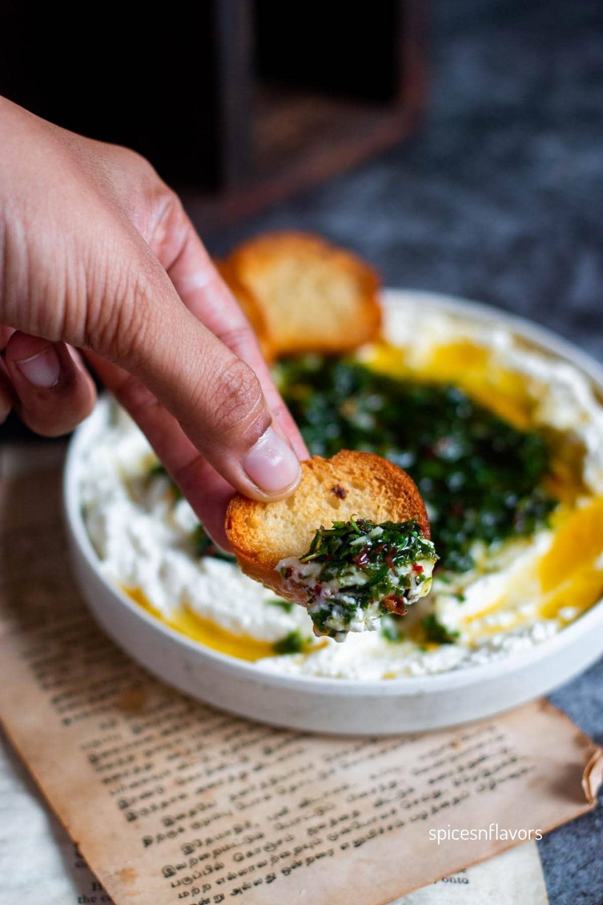 bread slice with ricotta dip and herb oil on top