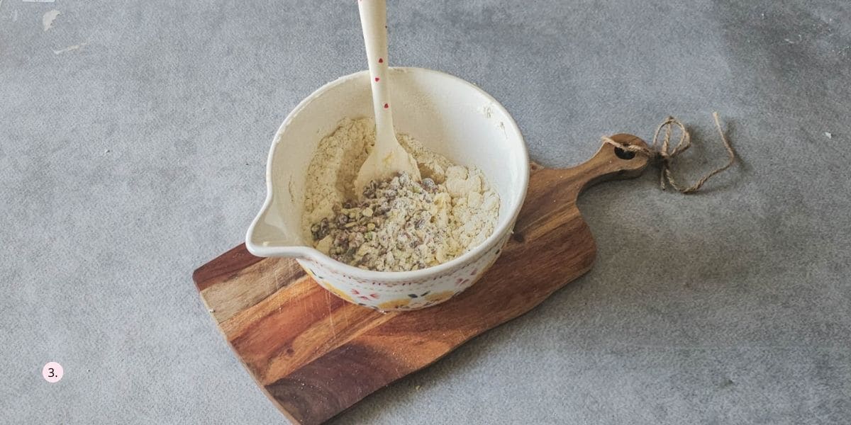 adding cranberries and pistachios to the cookie dough