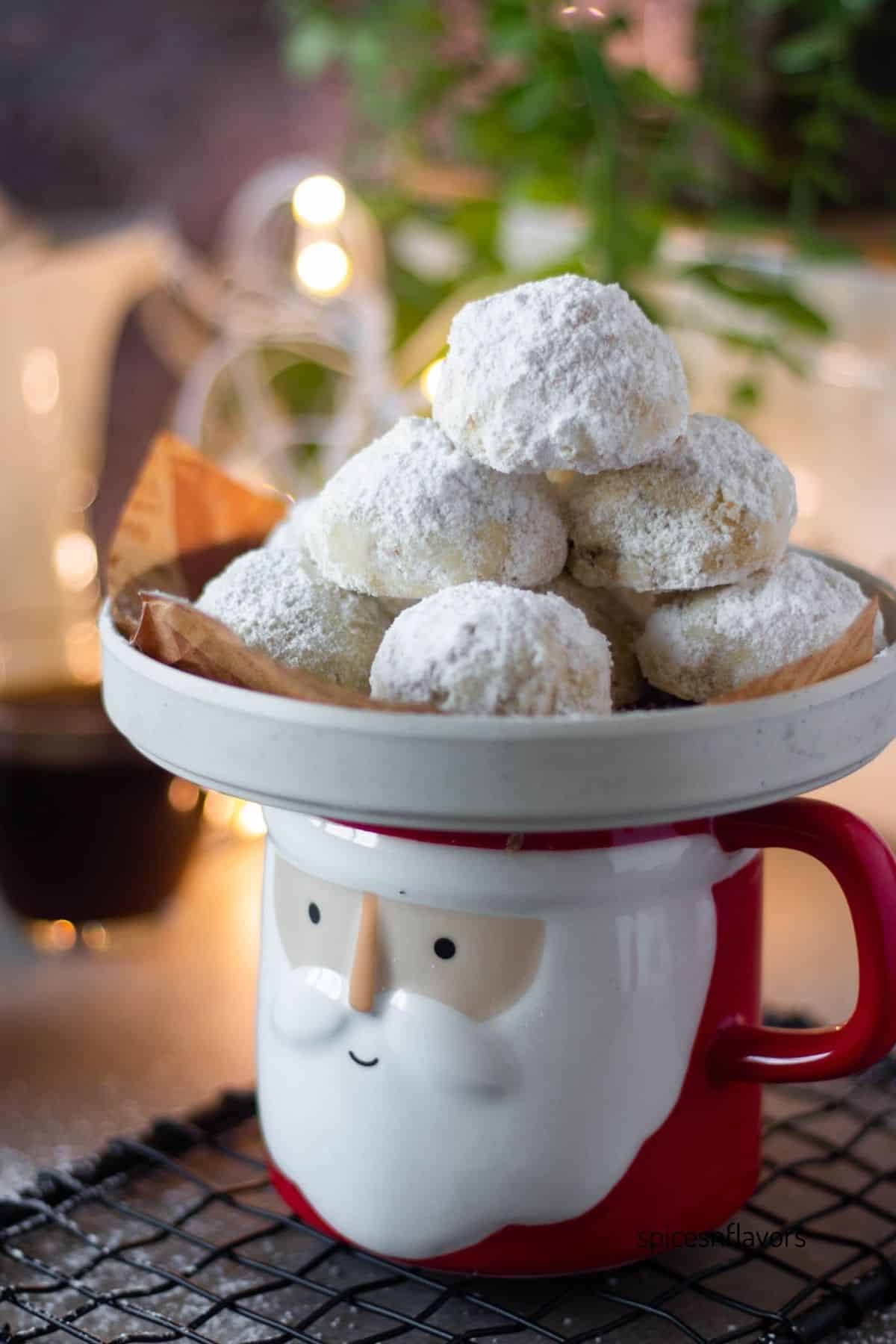 cranberry orange snowball cookies placed on a santa mug