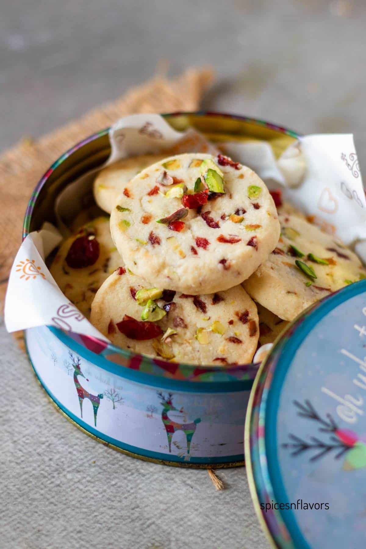 Cranberry Pistachio shortbread cookies placed in a cookie tin