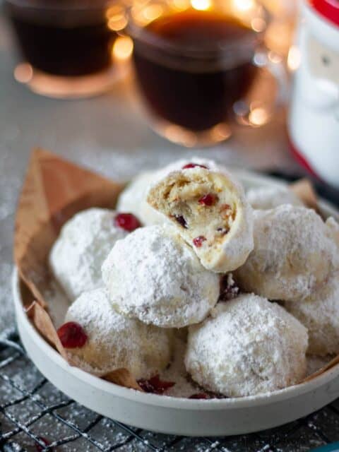 half eaten cranberry orange snowball cookies placed on a white plate