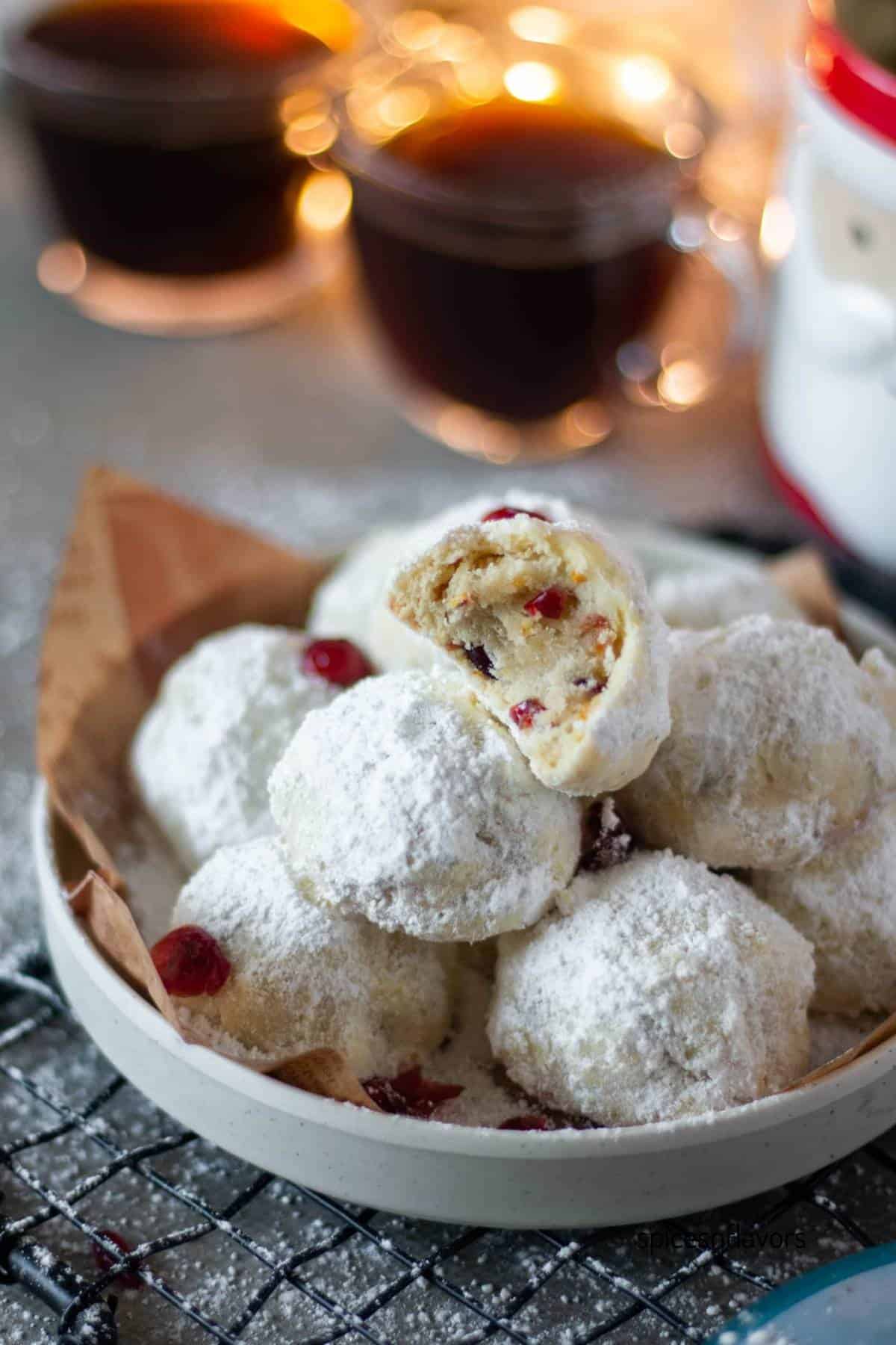 half eaten cranberry orange snowball cookies placed on a white plate