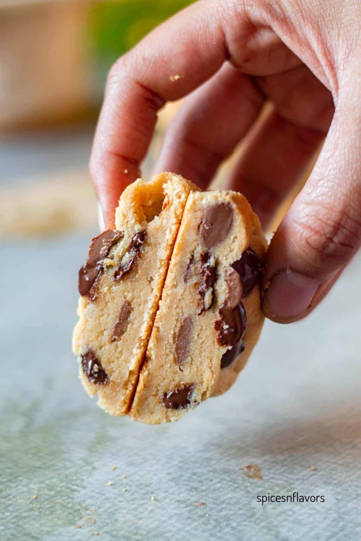sliced peanut butter chocolate chip cookies held in hand to show the texture