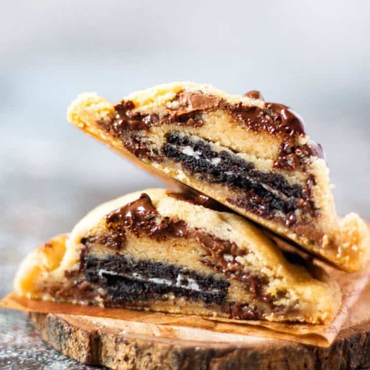 sliced oreo stuffed cookies placed on top of each other on a small wooden coaster