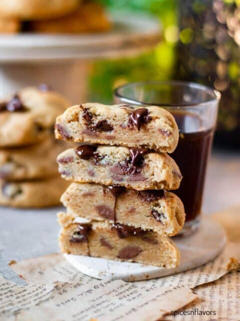 sliced peanut butter chocolate chip cookies stacked on top of each other with coffee on the side