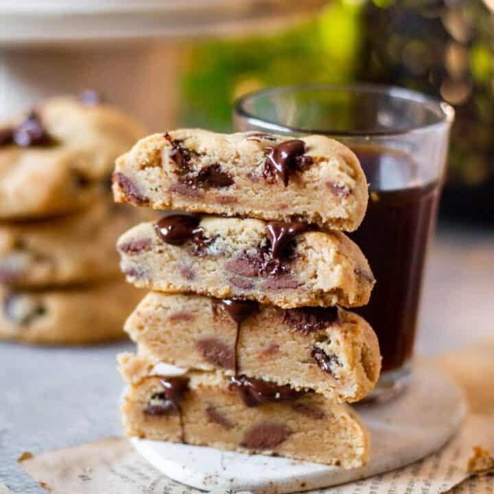 sliced peanut butter chocolate chip cookies stacked on top of each other with coffee on the side