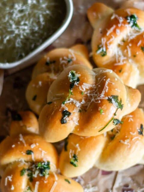 close up image of garlic knots on wooden board on recipe card