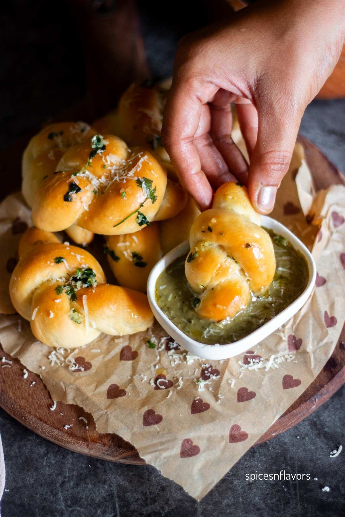 dipping garlic knot in pesto