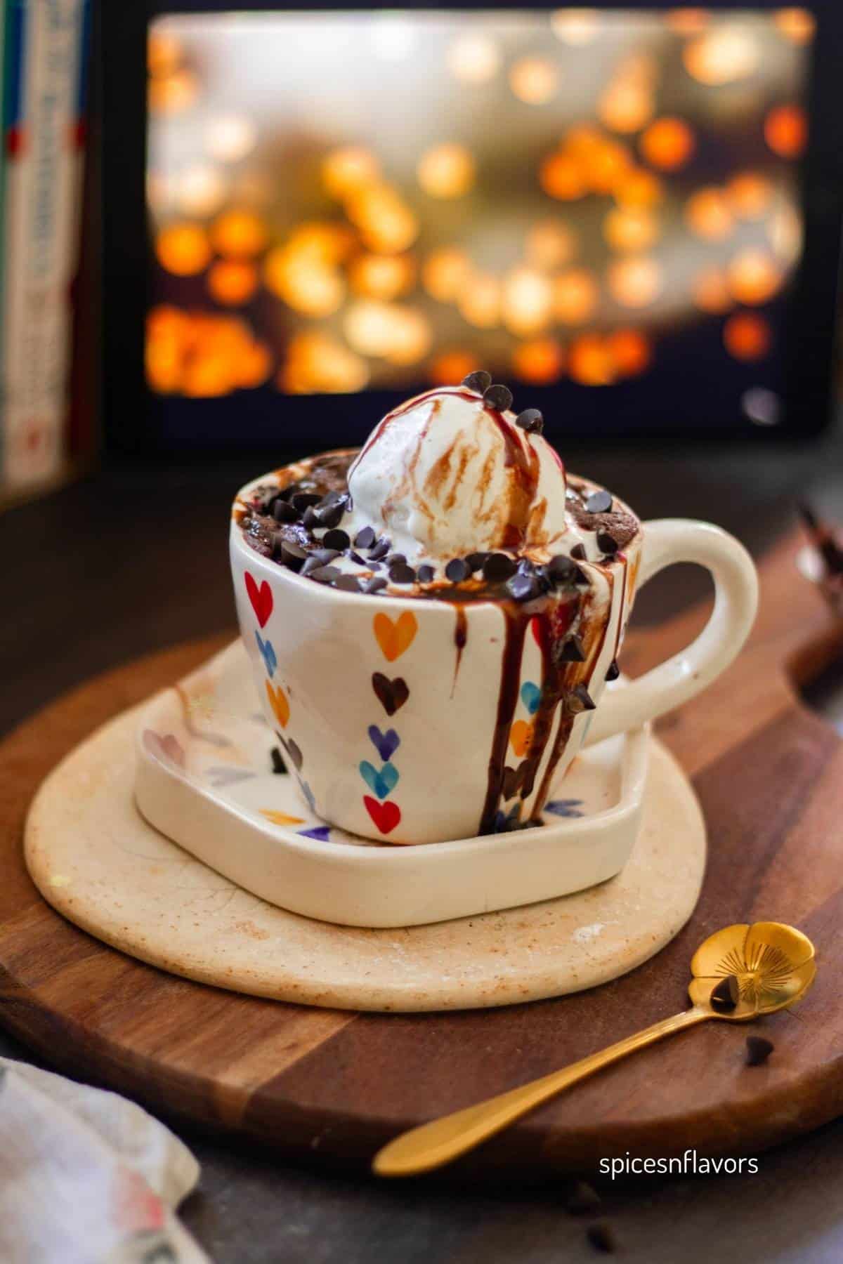 eggless chocolate cake in a mug with ice cream on top